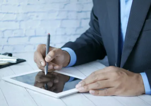 Ejecutivo tomando apuntes o firmando en una tablet