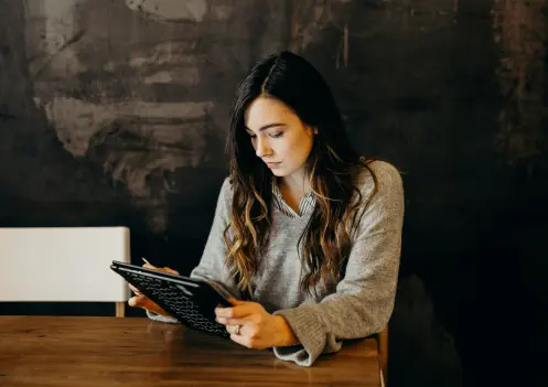 Mujer joven sentada con una tablet