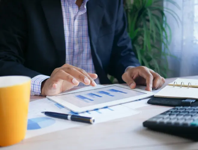 Ejecutivo analizando gráficas de barras desde una tablet